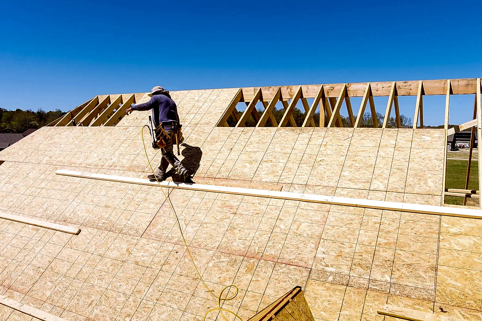 Aerial top view of home roof construction applying roof plywood panels in new house