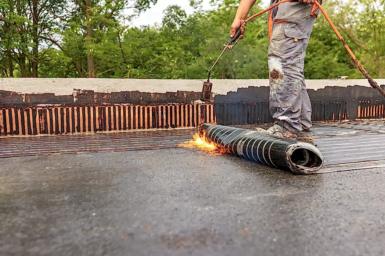 Bituminous membrane waterproofing system details and installation on flat rooftop.