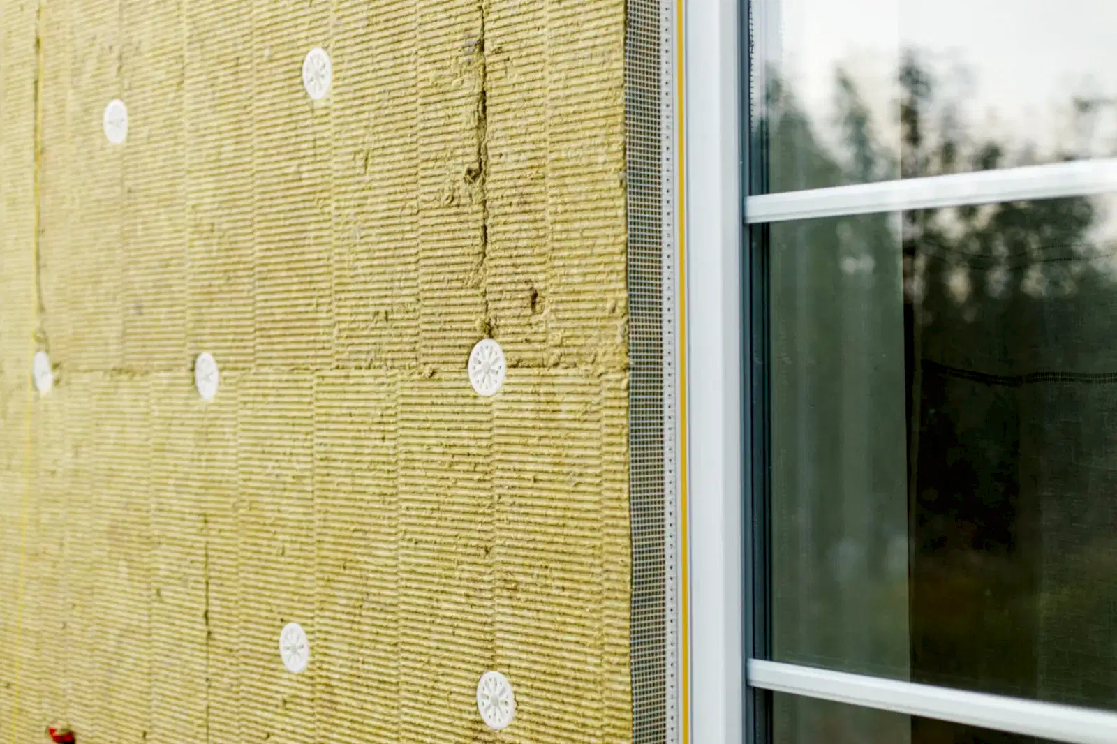 Facade insulation with mineral wool, thermal improvement and energy saving. Modern farmhouse renovation covering with stone wool panels close up. House insulation concept
